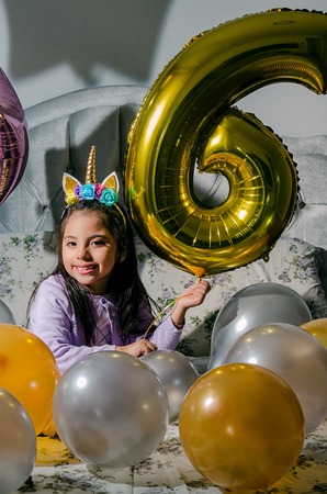 Happy Birthday to me Happy girl looking at the camera with balloons around herの写真素材