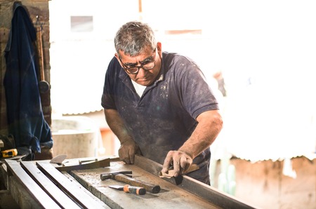 Professional carpenter sanding and restoring wooden surfaces.の写真素材