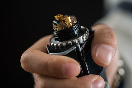 Modern electronic mech mod vaping device spare parts on black background.の写真素材