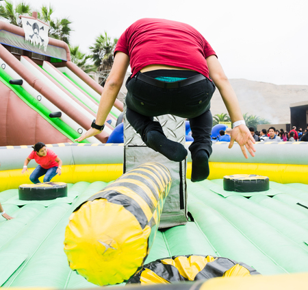 Young man jumping and dodging an obstacle in a game.の写真素材