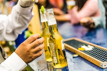 Lima, Peru - October 5th 2018: The waiter uncovers the ice cold beer for the guests at a midday party.のeditorial素材