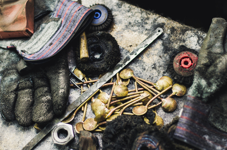 Top view of different goldsmiths tools on the jewelry workplace. Desktop for craft jewelry making with professional tools. Aerial view of tools over rustic wooden background.の写真素材