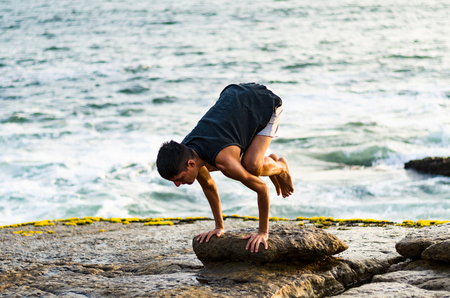 Summer yoga session on a beautiful golden beach of Lima in Peru yoga tour, Bakasana Crow Crane poseの写真素材