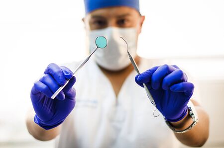 Dentist in uniform with surgical tools of dentist in dental clinicの写真素材