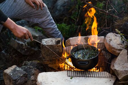 Friends camping eating food concept. A warm fire you to drink and camp in the mountains of Chiprac,...