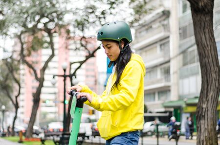 Young woman with helmet on an electric scooter in the cityの写真素材