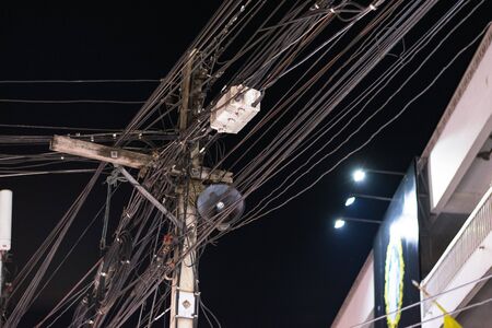 Complicated connection of many cables in a street of Thailand