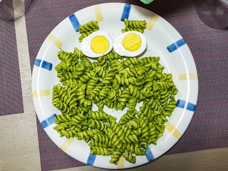 Plate with creative pasta for children on table