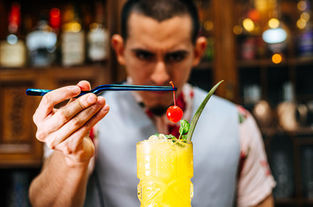 Bartender putting a cherry on a tiki cocktailの写真素材