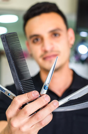 Barber Shop. Barber holds a razor to shave his beard.の写真素材