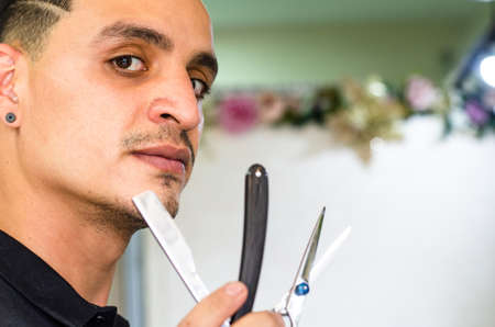 Barber Shop. Barber holds a razor to shave his beard.