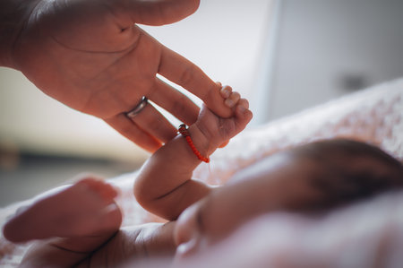 mothers hand holds the hand of a newborn. little baby fingers. love, family values, family medicine, healthcare, maternity hospital.の写真素材