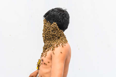 Mans face covered by bees.の写真素材