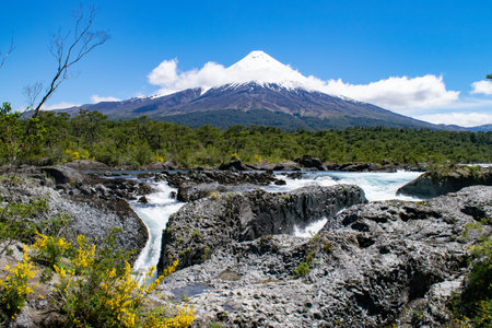Majestic volcano overlooking turbulent riverの写真素材