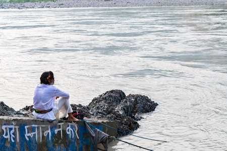 Indian man relaxing by ganges river at rishikesh india