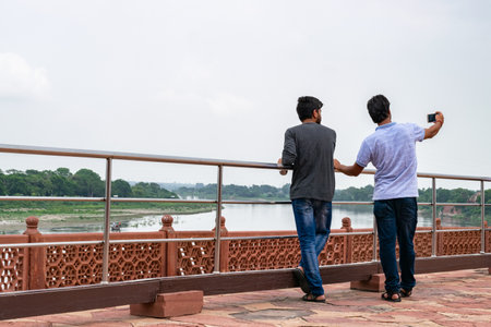 Two tourists taking a selfie with river view in indiaの写真素材
