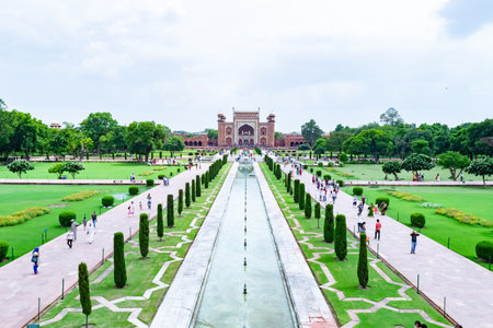 Tourists walking in mughal gardens of taj mahal complex in agra, indiaの写真素材