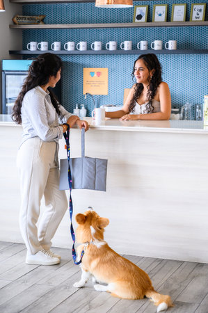 Woman with dog talking to barista in pet friendly coffee houseの写真素材