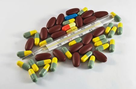 thermometer and pills is on a grey backgroundの写真素材