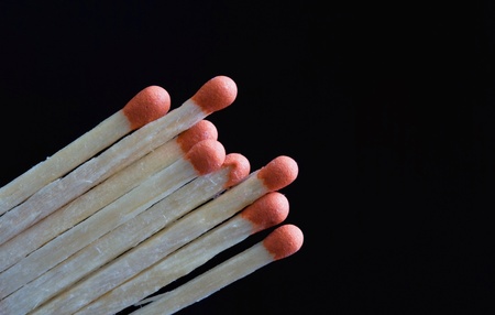 wooden matchsticks against black background の写真素材