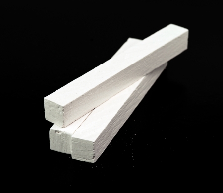 stick of chalk on a blackboard isolated background の写真素材