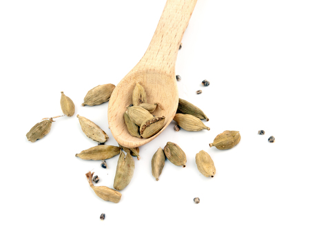 wooden shovel with cardamom pods scattered from itの写真素材