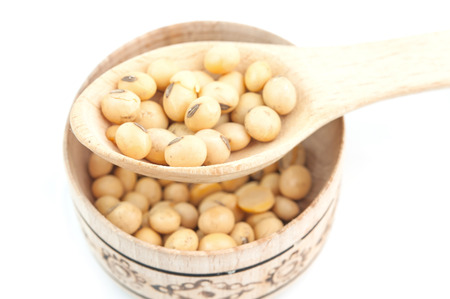 soybeans on wooden spoon in a wooden bowl on a white backgroundの写真素材