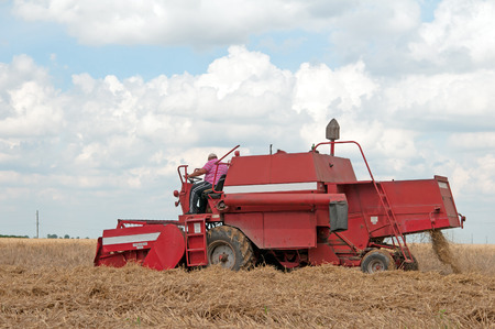 Amazing rural scene on autumn field with harvester