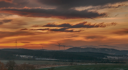 winter landscape during the sunrise with fog and a windmillの写真素材