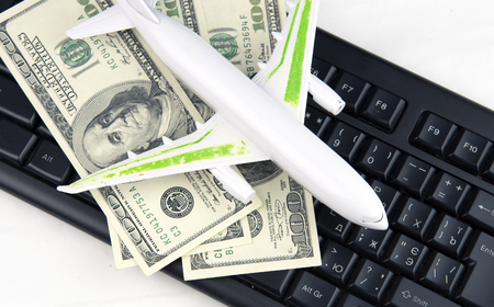 model plane on computer keyboard and moneyの写真素材