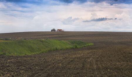Farmer seeding, sowing crops at field. Sowing is the process of planting seeds in the ground as part of the early spring time agricultural activities.の写真素材