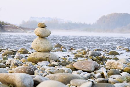 Stones balances on the beach of blue sea with mountainの写真素材