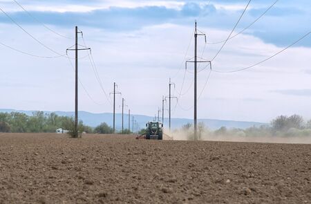 Farmer seeding, sowing crops at field. Sowing is the process of planting seeds in the ground as part of the early spring time agricultural activities.の写真素材