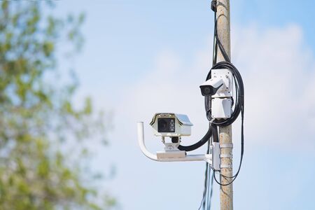 Surveillance cameras in front of blue sky