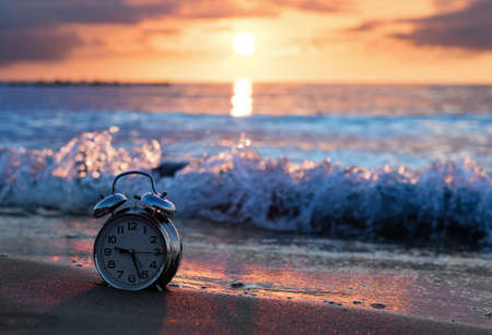 Alarm clock vintage with sunset on beachの写真素材