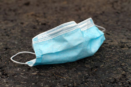 medical mask used for the anti-corona virus that were used were left on the road. Improper removal of the mask caused Covid-19 to spreadの写真素材