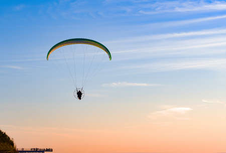 Paragliding concept, paraglider pilot fly in sky on beauty nature sea coast landscape Baltic sea....