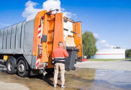Worker of urban municipal recycling garbage collector truck loading waste and trash binの写真素材