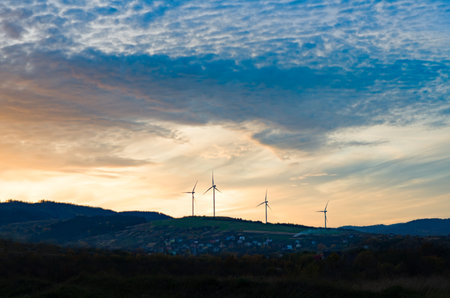 Wind turbines (green energy and technology) at sunset with beautiful colorful sky at the backgroundの写真素材
