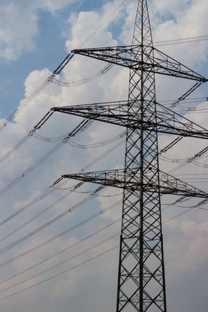 High voltage mast before cloudy skyの写真素材
