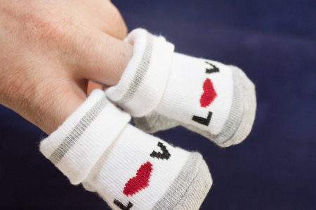 hands holding small baby socks.の写真素材