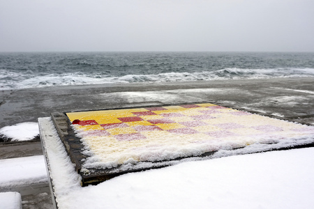 Empty Chess Board Tabel covered with snow at the seaの写真素材