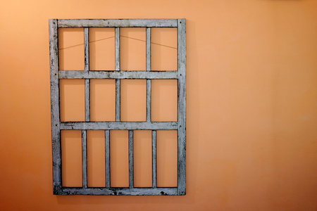 Decorative vintage old and wooden window frame of light color on a red terracotta background wall with copyspaceの写真素材