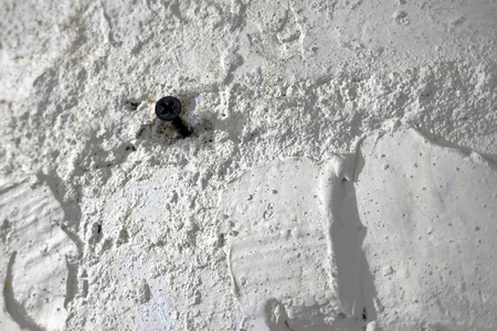 White brick wall texture closeup with black screw. concept of immigrant problemsの写真素材