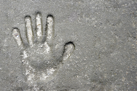 Memorable handprint of a hand in an old concrete wall