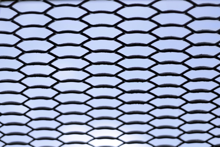Metal fence grid over sky backgroundの写真素材