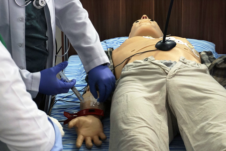Medical simulation procedure. Medical student as a doctor performing iv injection to a mannequin...