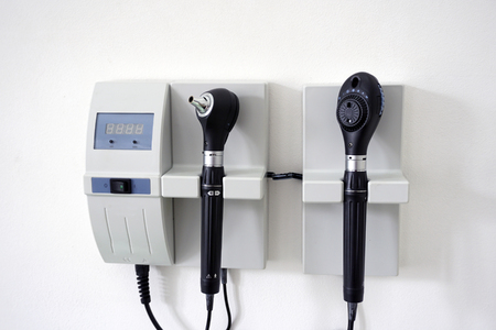 Medical Equipment with otoscope ear scope and ophthalmoscope eye scope hanging on a doctor's office...