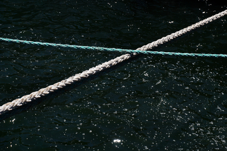 Two ropes crossing each other on a water background.の写真素材