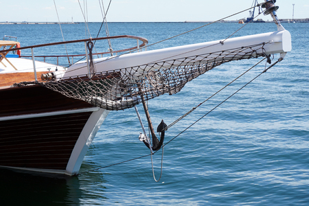 Bow of a black sailing yacht against the blue sea with anchor at the bow. copy space, selective focus, narrow depth of fieldの写真素材
